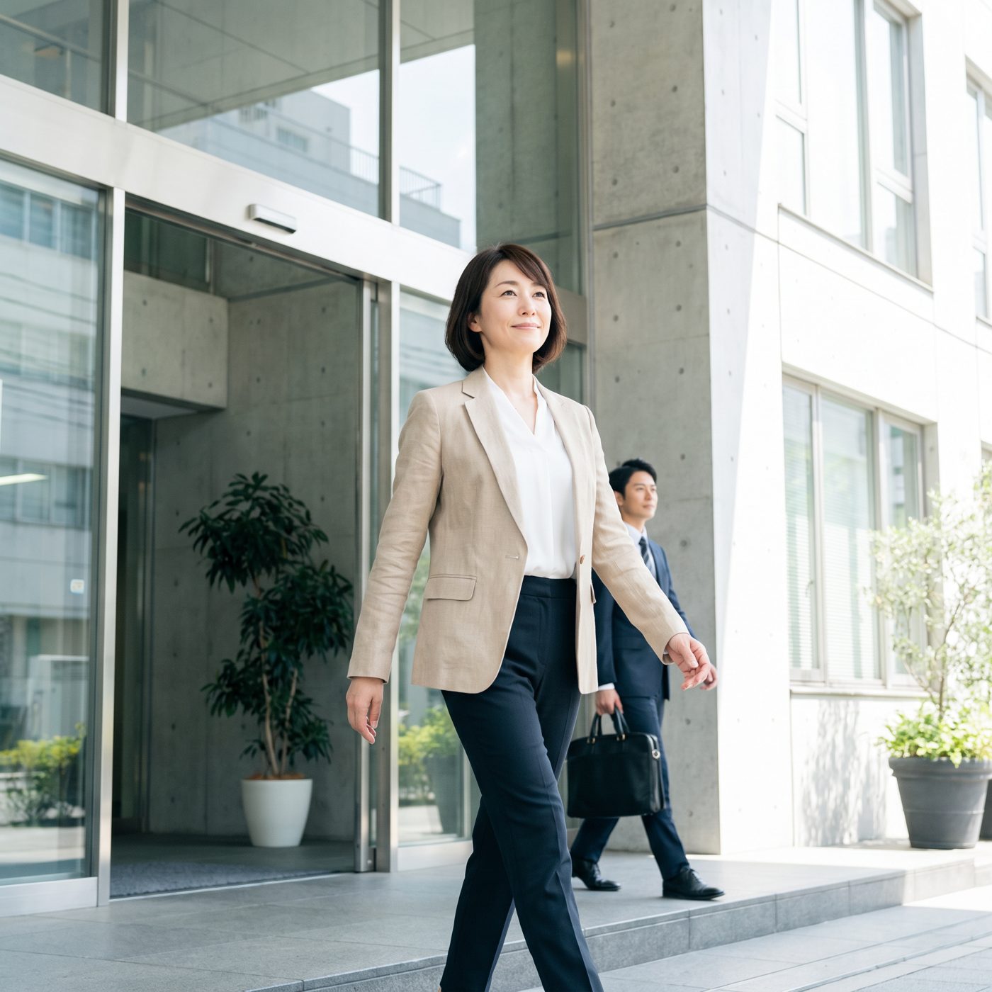 弁護士とともに建物から出てくる、前を向いた女性