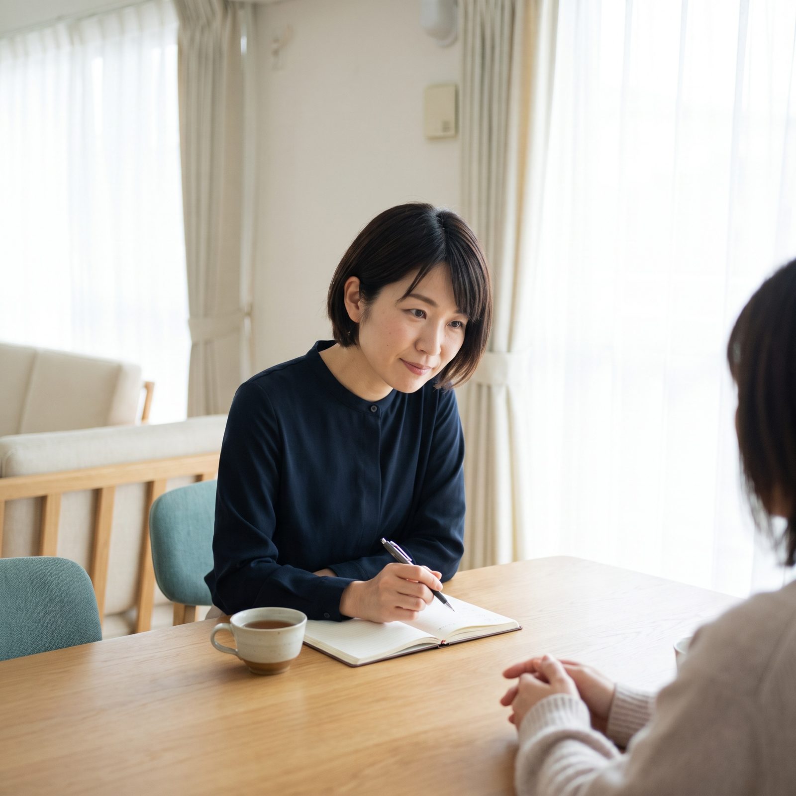 明るい相談室で、話を聞きながらメモを取るスタッフ