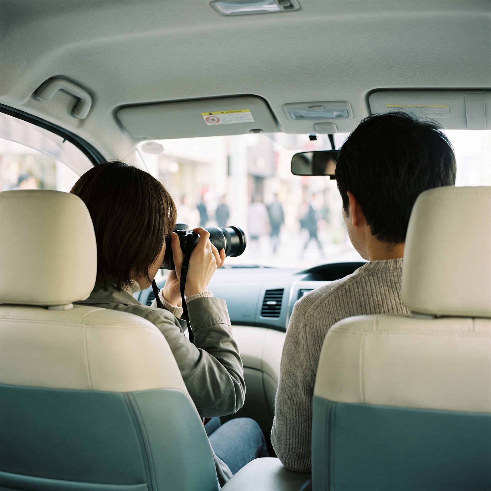 車内から望遠レンズで確認する調査員